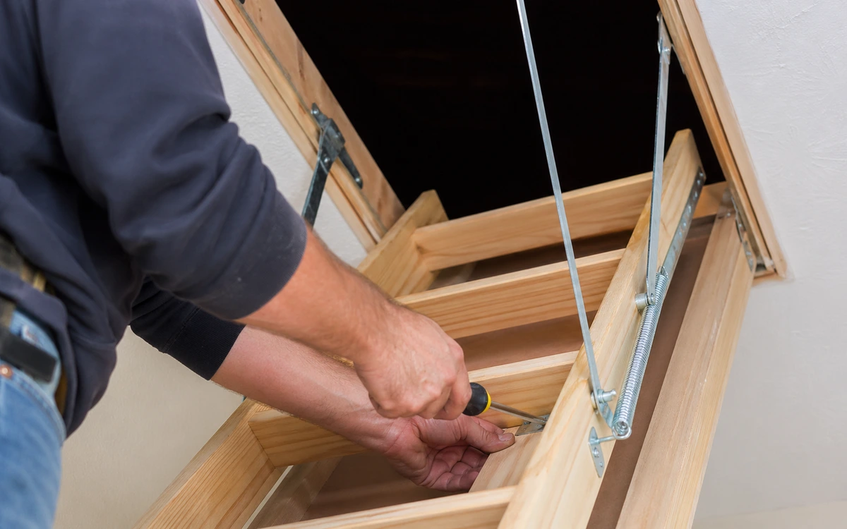 Attic stair installation contractor hands closeup